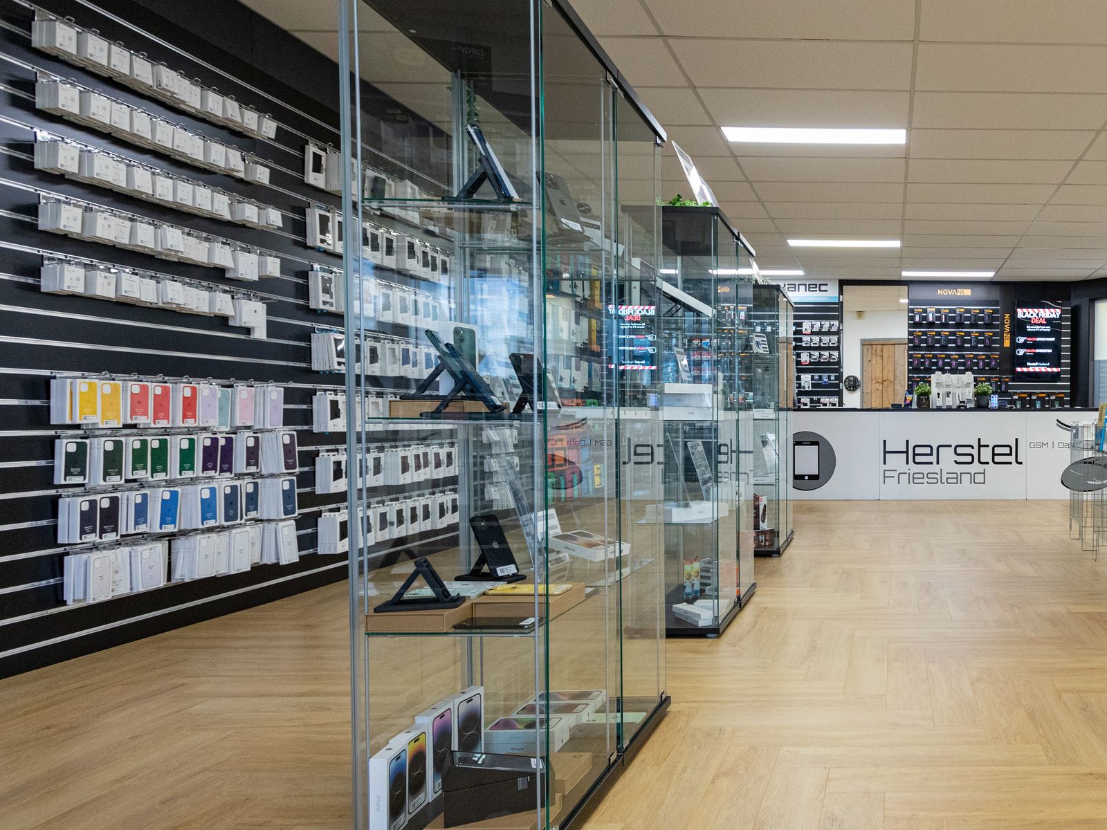 Vitrine met telefoons en wand met hoesjes in de winkel van Herstel Friesland in Dokkum